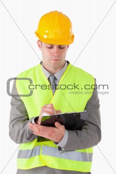 Portrait of a young builder taking notes