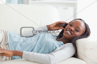 Woman lying on couch with phone