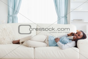Woman lying on sofa with mobile phone