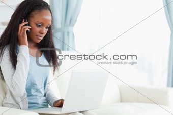 Woman on the phone while using laptop