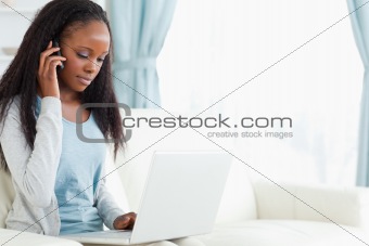 Woman on the phone while using notebook
