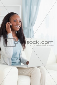 Woman on her phone while using notebook