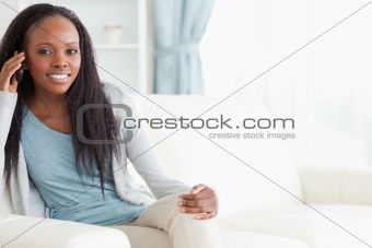 Woman sitting on sofa while using her phone