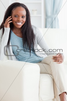 Woman sitting on couch while using her mobile phone