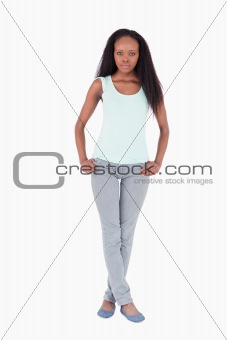 Woman standing with legs crossed on white background