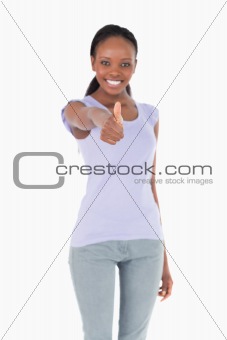 Close up of thumb up being given by woman on white background