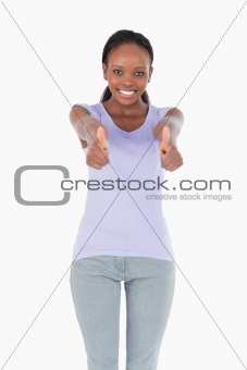 Close up of woman giving thumbs up on white background