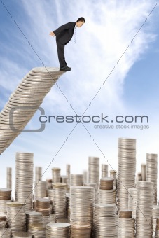surprised businessman standing on the money stairs and watching many coin towers