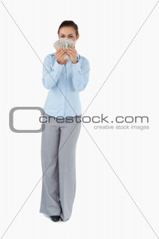 Businesswoman smelling banknotes