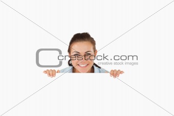 Smiling businesswoman looking over wall