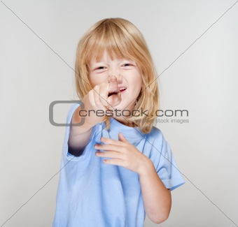 boy with long blond hair pointing towards the camera - focus on finger