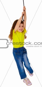 Little girl swinging on a rope