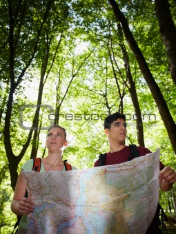 young couple looking at map during trek 