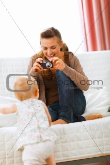 Modern mother making photos of baby
