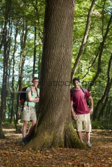 environmental conservation: young hikers leaning on tree