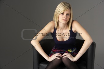 Studio Portrait Of Teenage Girl Sitting In Chair
