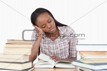 Young woman almost falling asleep while reading