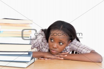 Student looking at a stack of books
