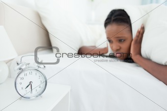 Woman being awakened by her alarm clock
