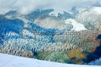 First winter snow and last autumn colorful foliage in mount