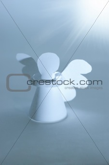 Handmade angel cut out from  paper at bright star lighting. Reli