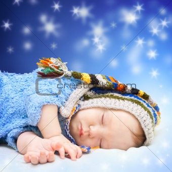 Baby sleeping in cute hat. Magic night sky background.