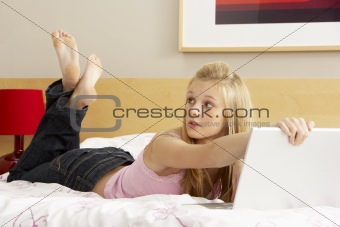 Guilty Teenage Girl Using Laptop In Bedroom