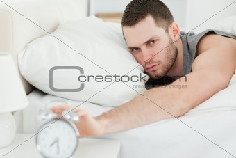 Man switching off his alarm clock