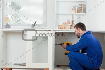 Good looking handyman fixing a door