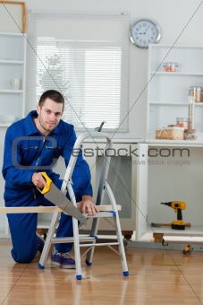 Portrait of a handyman cutting a wooden board