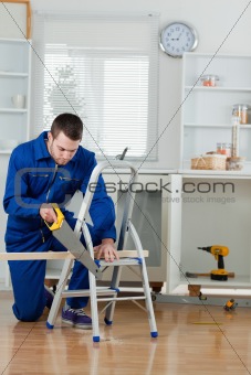 Portrait of a young handyman cutting a wooden board