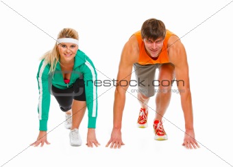 Healthy young man and fit female in start position ready for run race isolated on white
