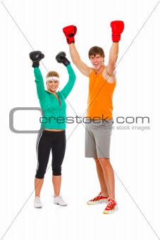 Male and female par in boxing gloves celebrating victory isolated on white
