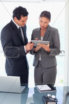 Tradesman explaining functionality of tablet to his colleague