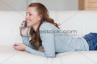 Female on the sofa having a joyful conversation on the phone