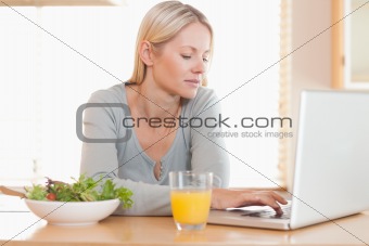 Woman having healthy lunch while working on her laptop