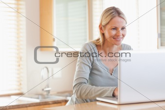 Smiling woman typing on her laptop