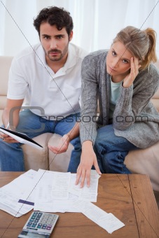 Portrait of a worried young couple looking at their bills