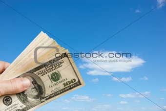 Hand holds up $100 bills