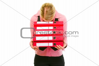 Tired female business clerk put her head on folders stack
