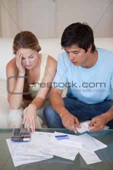 Portrait of a worried couple looking at their bills