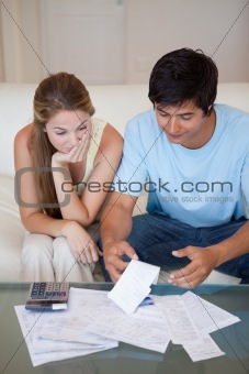 Portrait of a sad couple looking at their bills