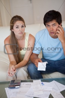Portrait of a worried couple looking at their receipts