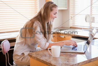 Woman having coffee while using a notebook
