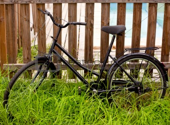 black grunge bicycle aged on a wood fence