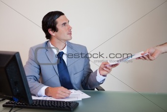 Businessman giving paperwork to colleague