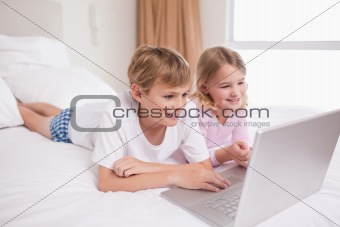 Smiling children using a notebook