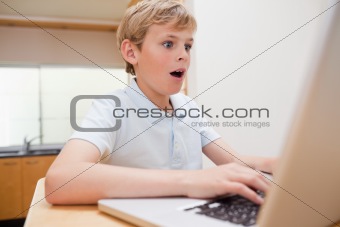 Surprised boy using a notebook