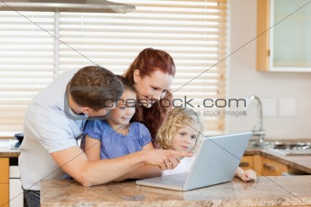 Family with laptop in the kitchen