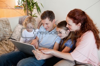 Family using notebook on the sofa